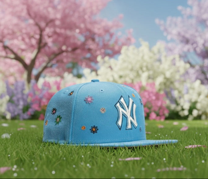 Blue cap with a logo on grass with cherry blossom trees in the background